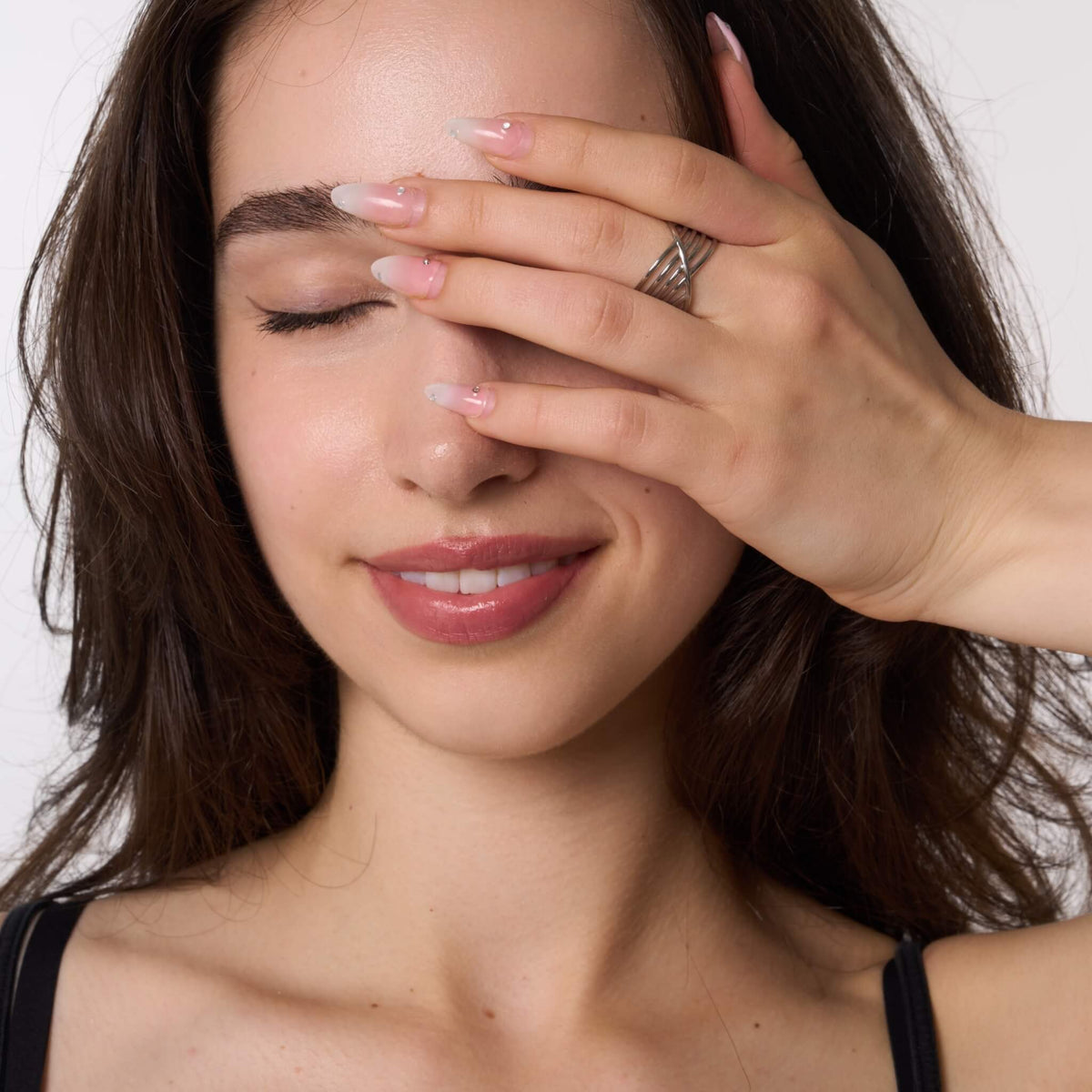 Silver crossover ring worn on a hand across the forehead